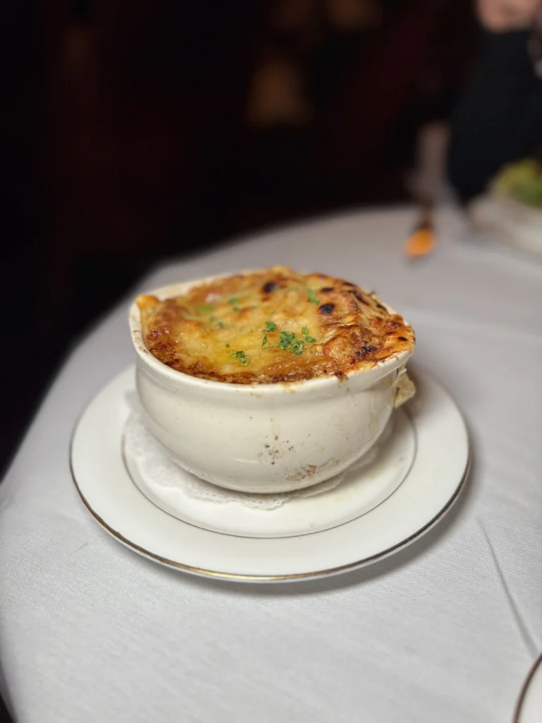 Classic French onion soup with melted Gruyere in white crock