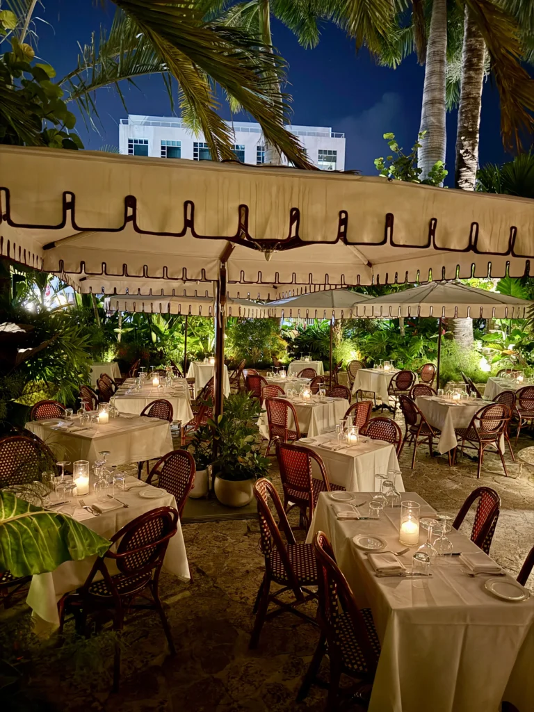 Candlelit outdoor garden patio with white tablecloths and bistro chairs