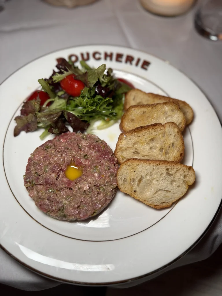 Prime steak tartare with quail egg, crostini, and side salad
