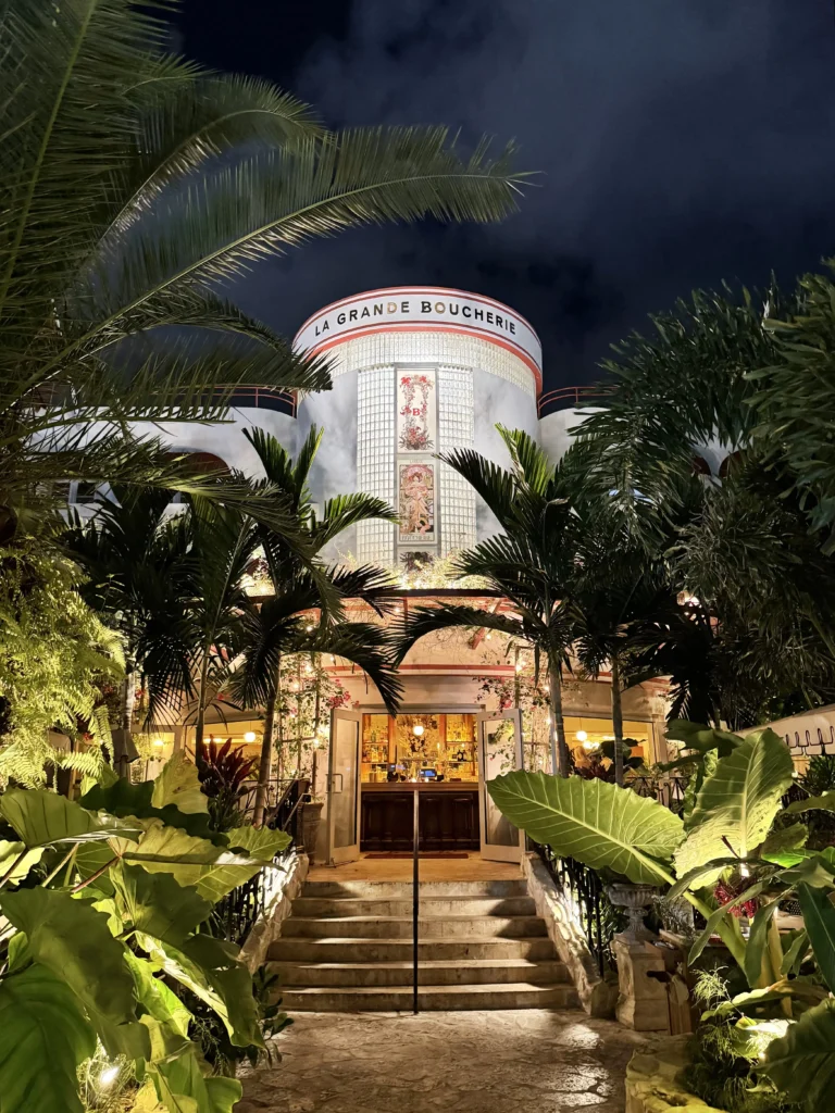 La Grande Boucherie Miami art deco exterior with palm trees at night
