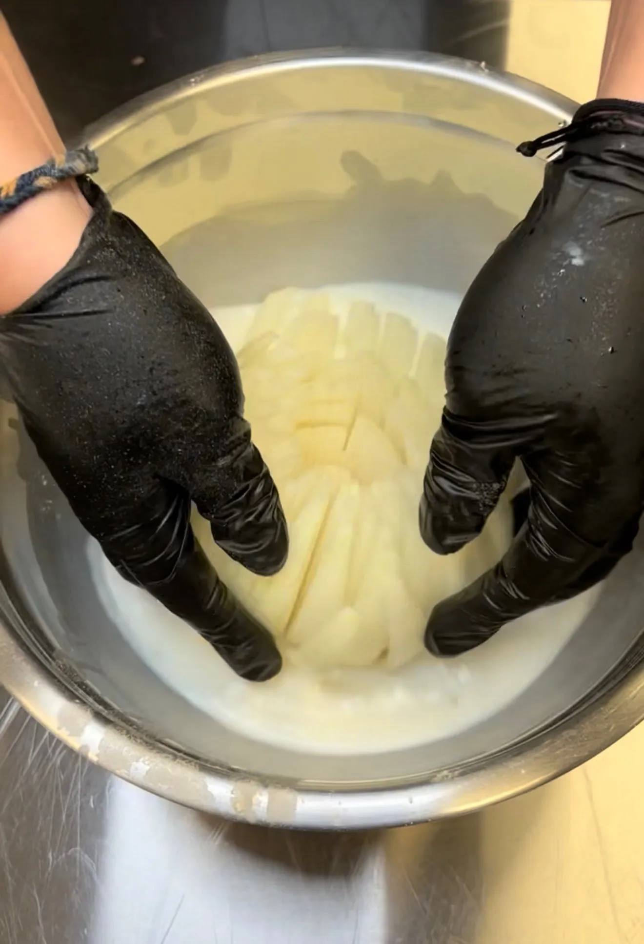 Blooming onion being prepared in a mixing bowl before battering