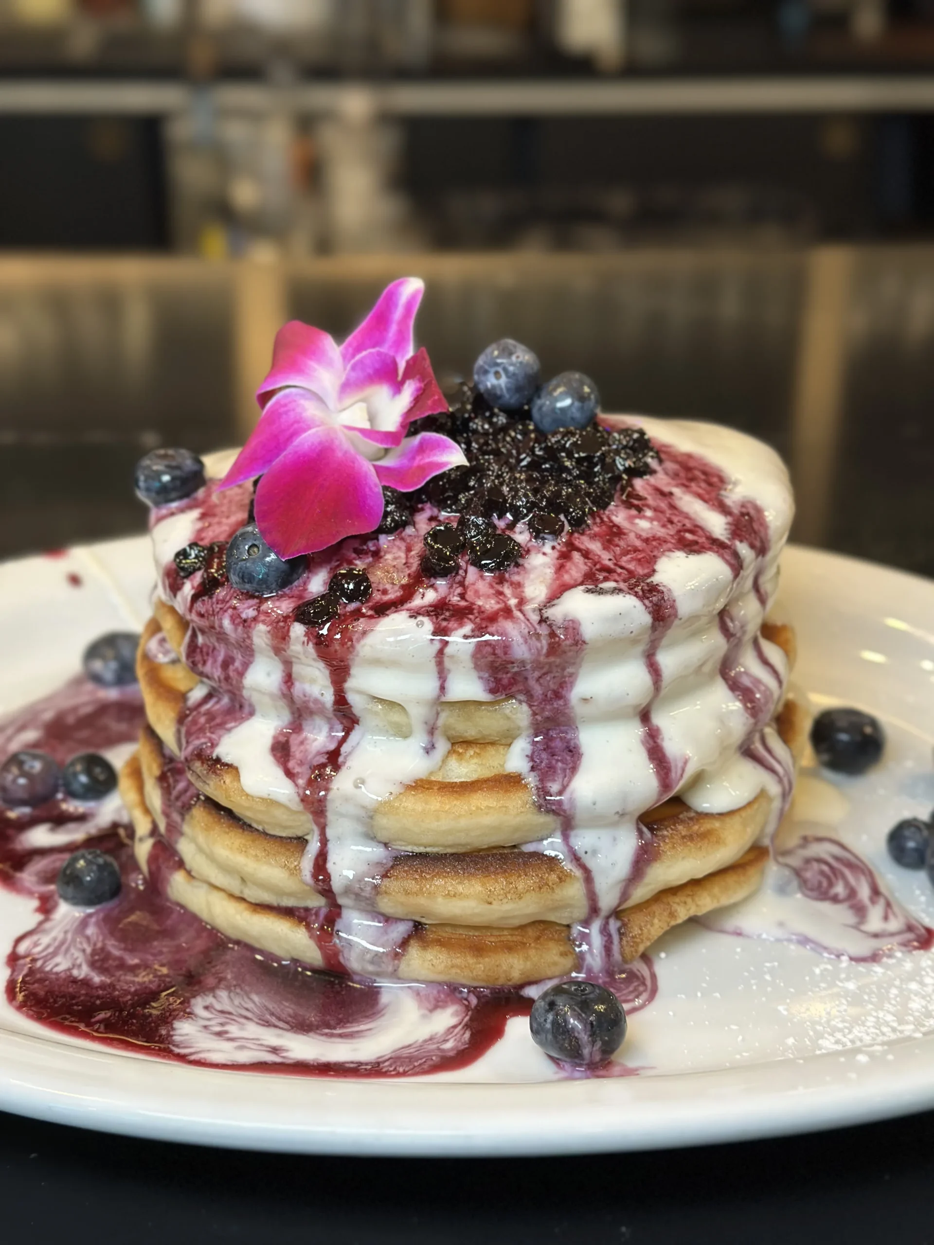 Blueberry pancakes with whipped cream and berry sauce