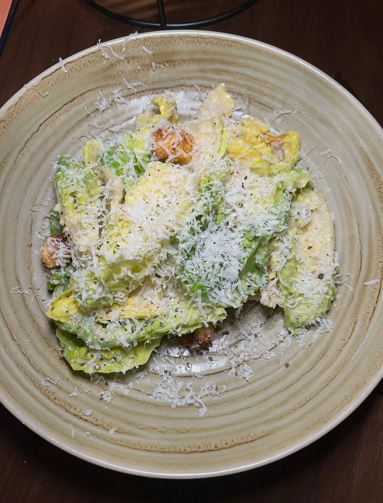 Classic Caesar salad with romaine lettuce, grated parmesan cheese, and croutons on a ceramic plate
