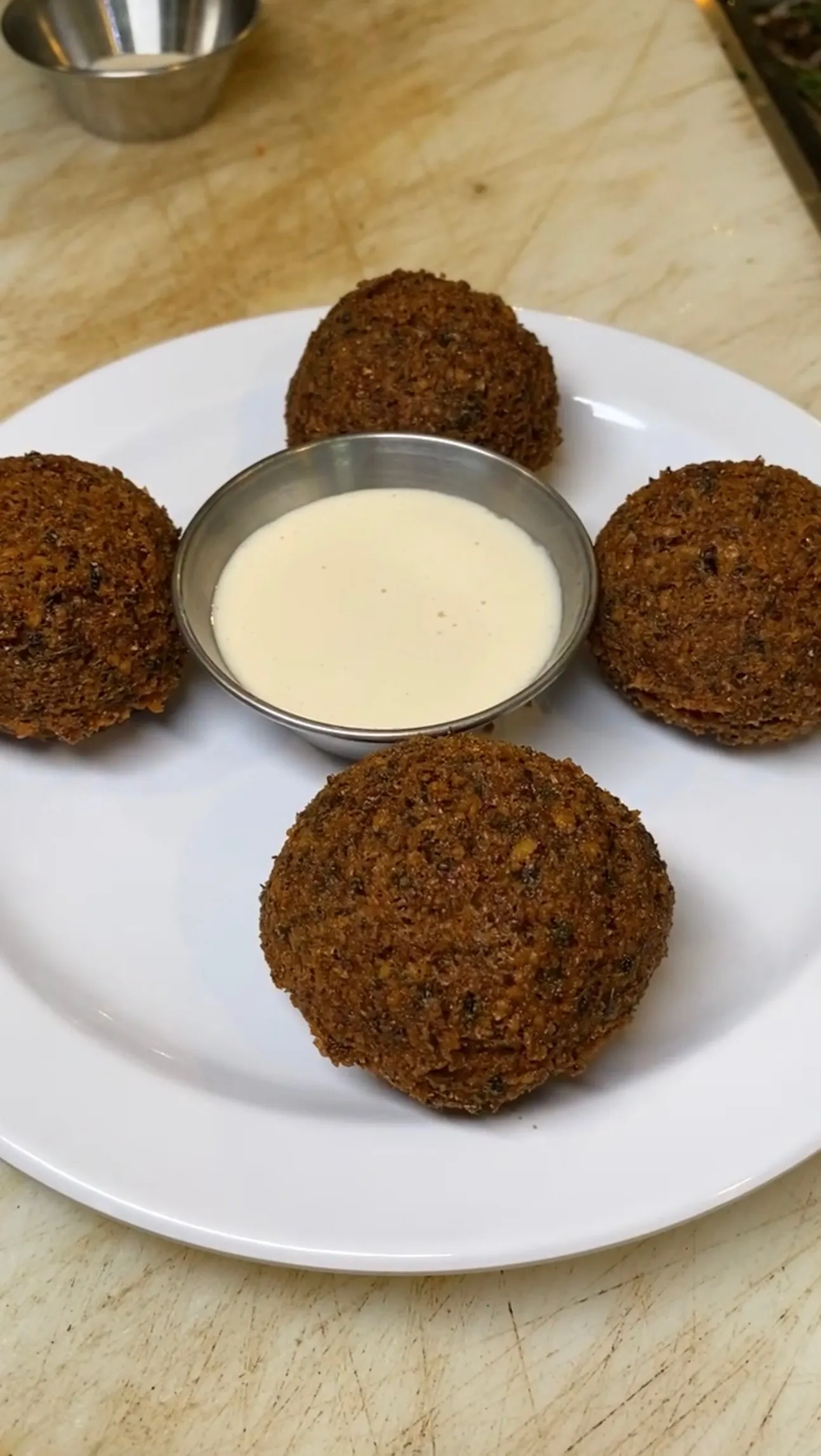 Crispy homemade falafel balls with tahini sauce on a white plate