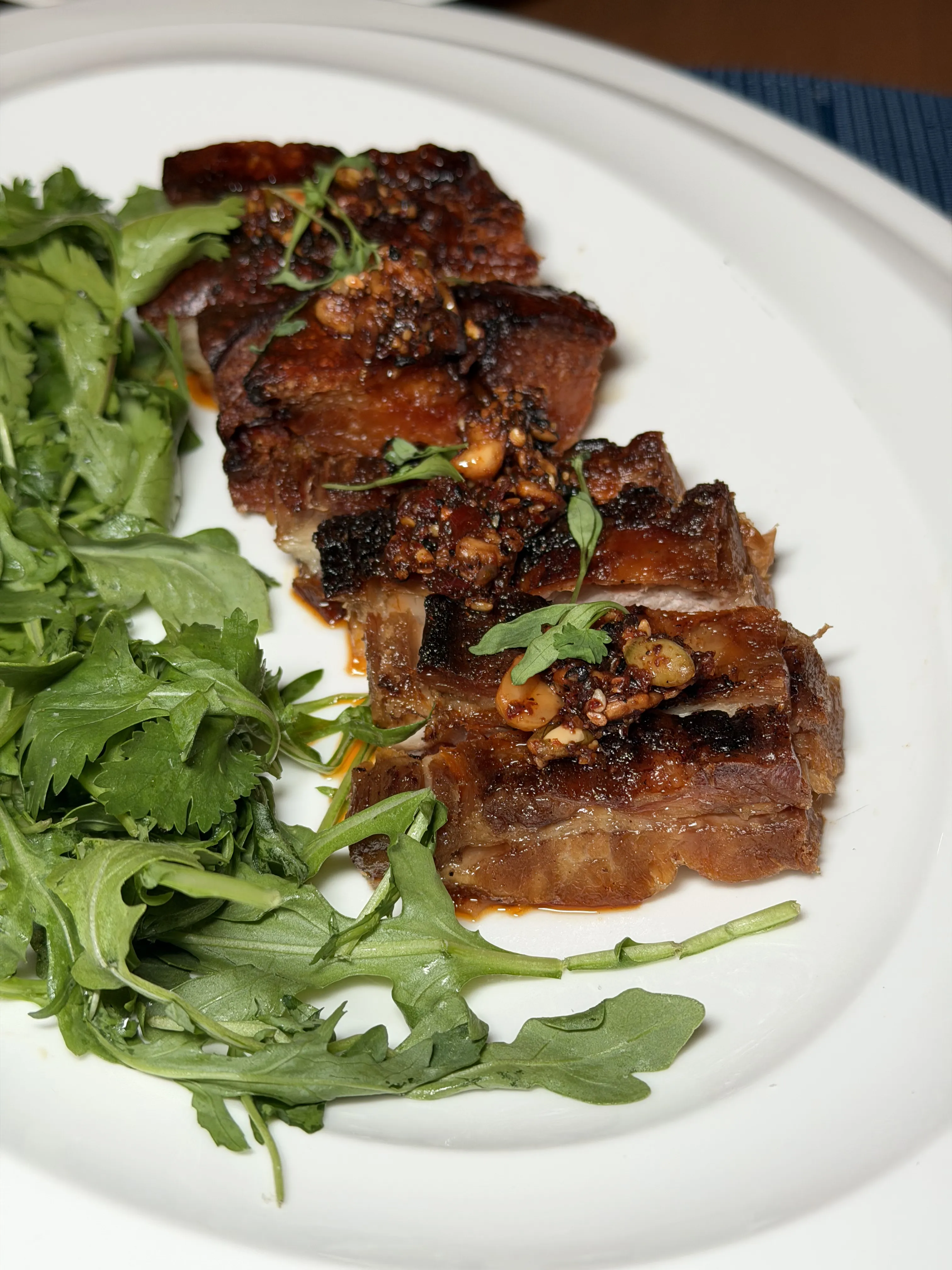Crispy pork belly slices with arugula salad and salsa macha