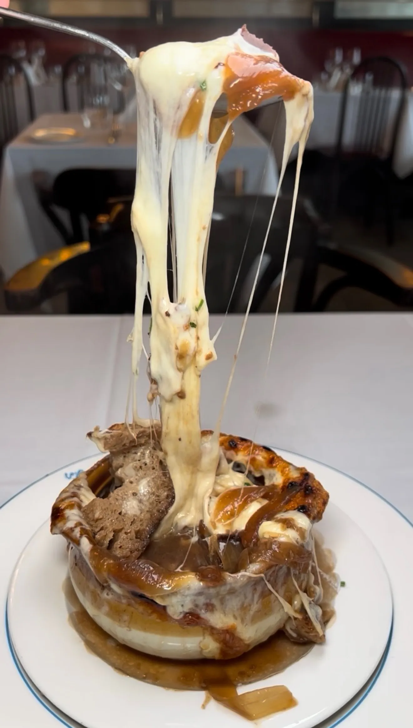 French onion soup melted cheese pull showing stretchy Gruyere