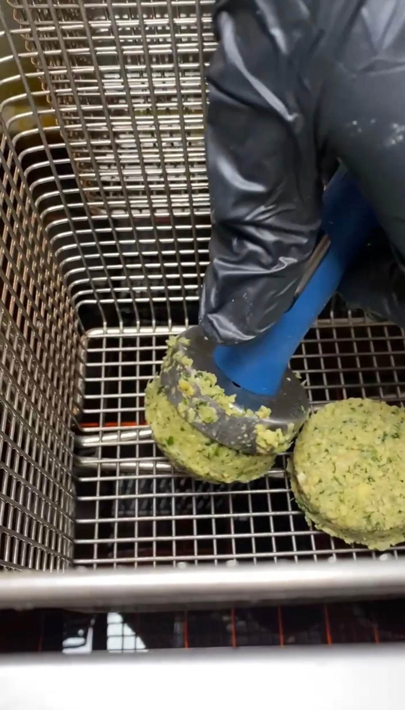 Fresh falafel balls frying in a basket until golden brown