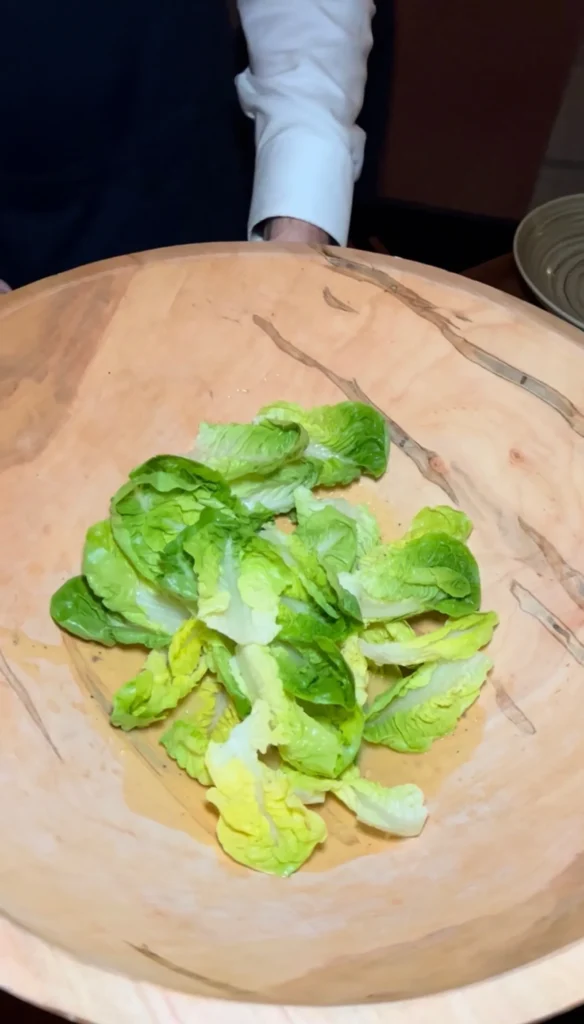Fresh romaine lettuce leaves in a wooden salad bowl, prepared for classic Caesar salad