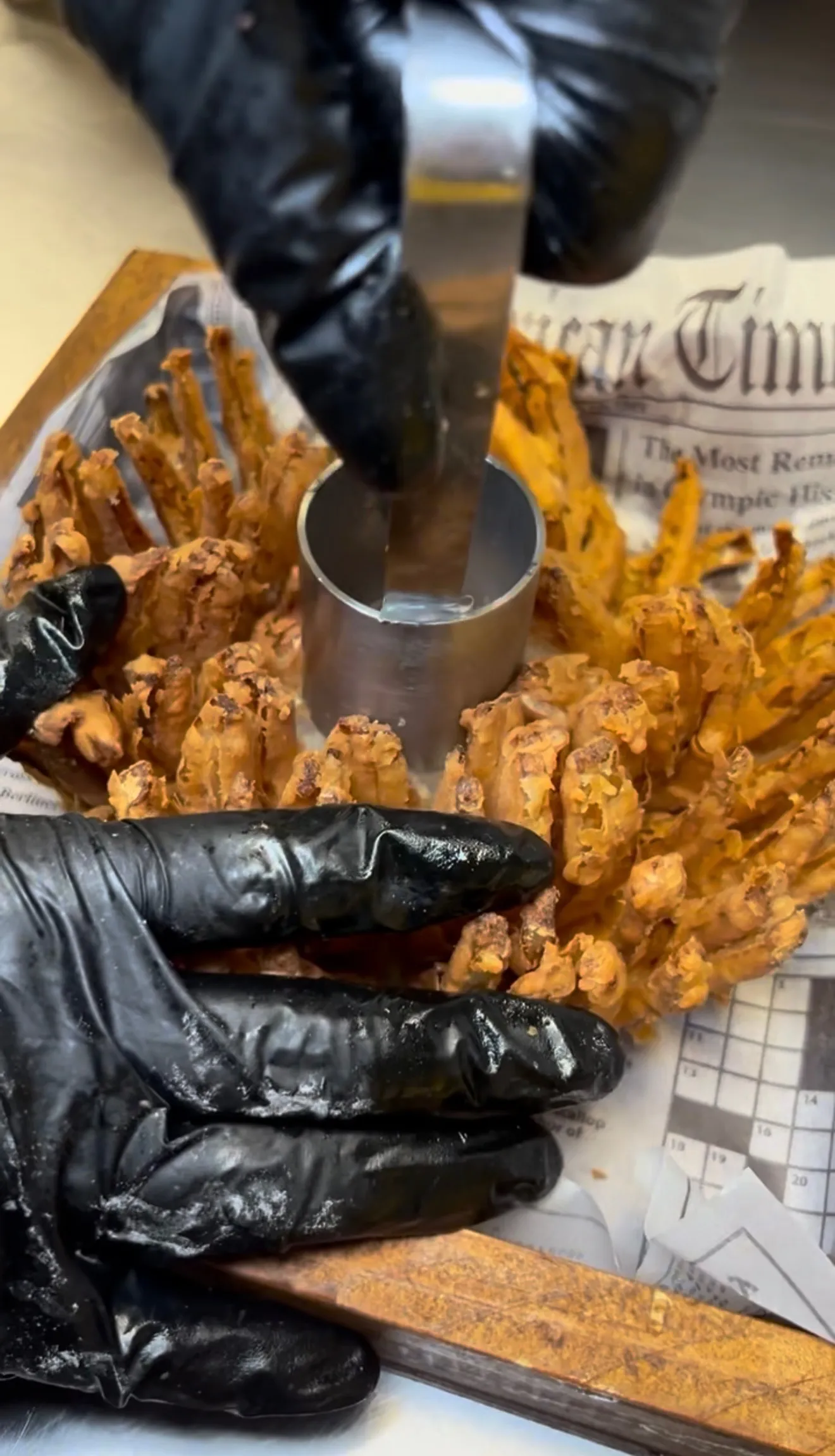 Golden blooming onion cut open with dipping sauce on the side