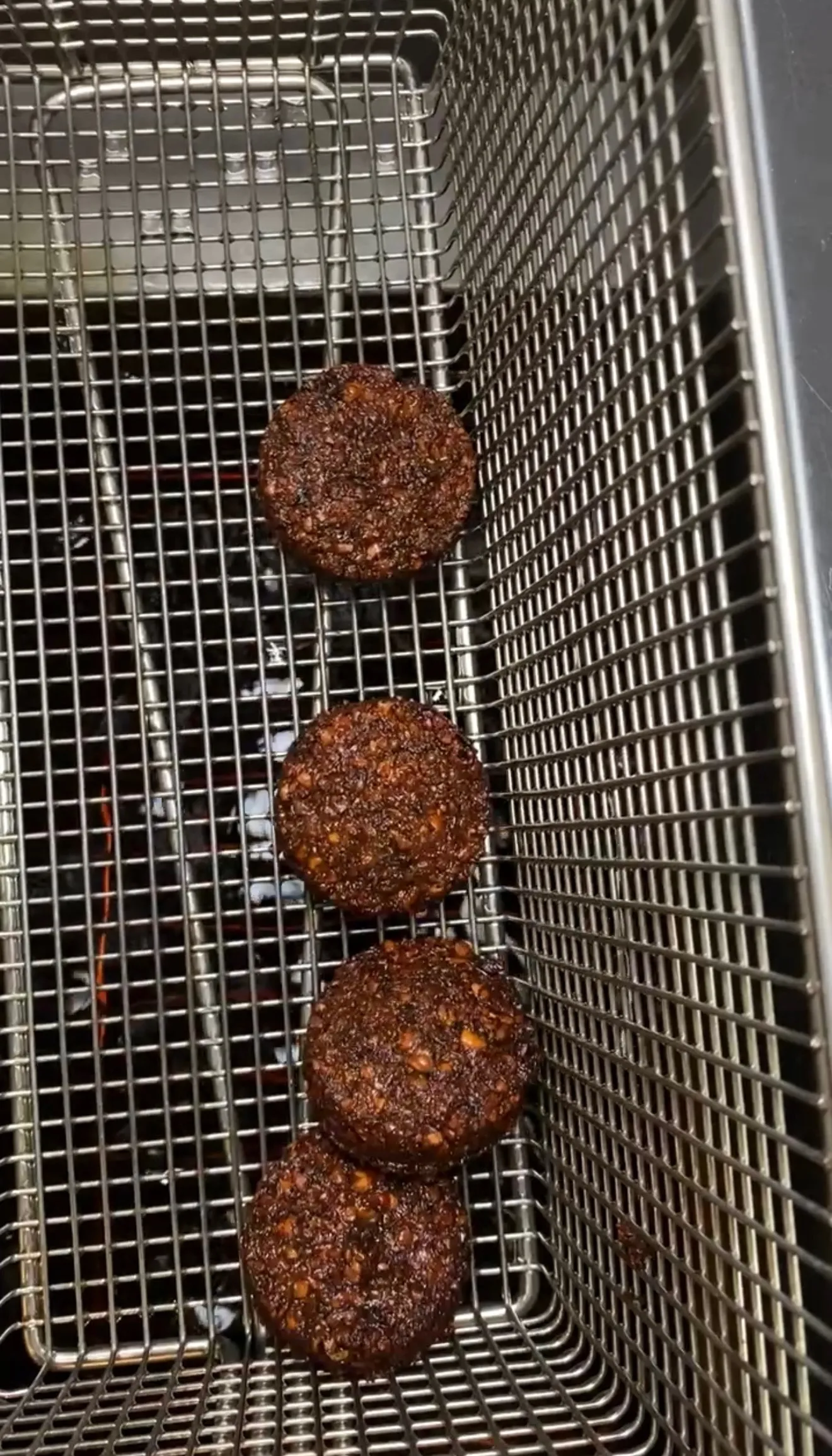 Homemade falafel balls in an air fryer basket