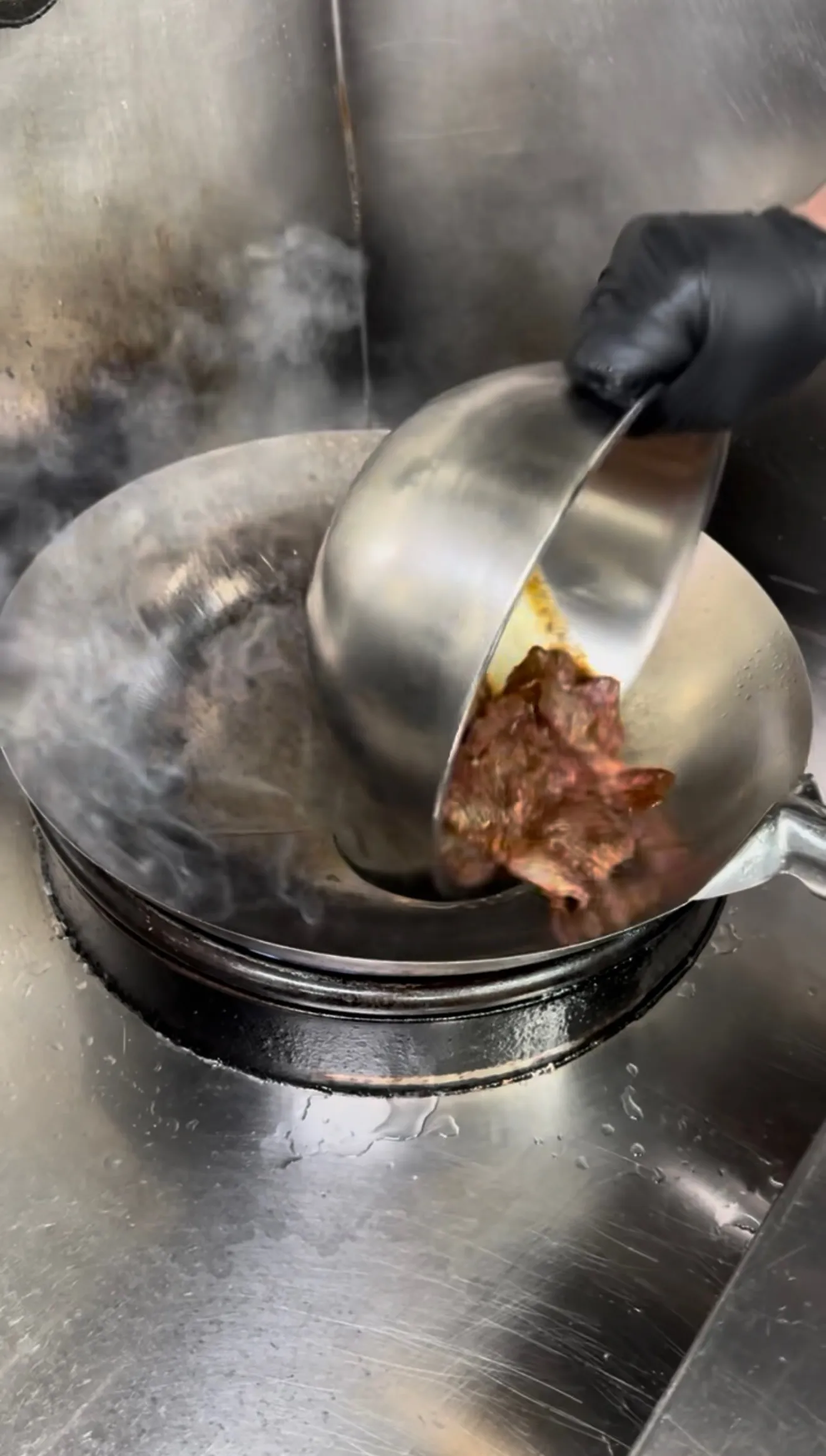 Beef strips searing in a hot wok for lomo saltado