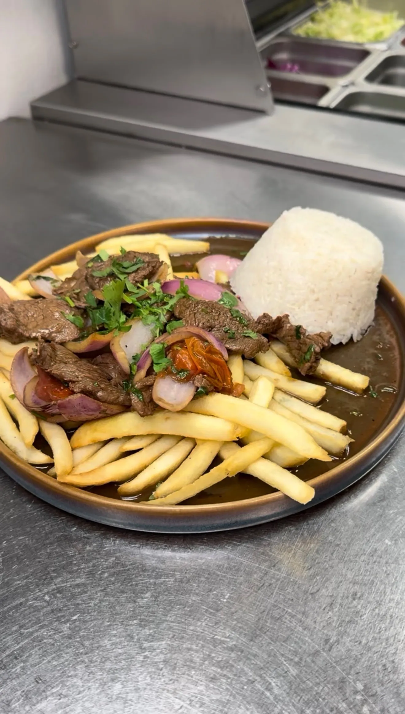 Lomo saltado Peruvian stir fry plated with white rice and french fries