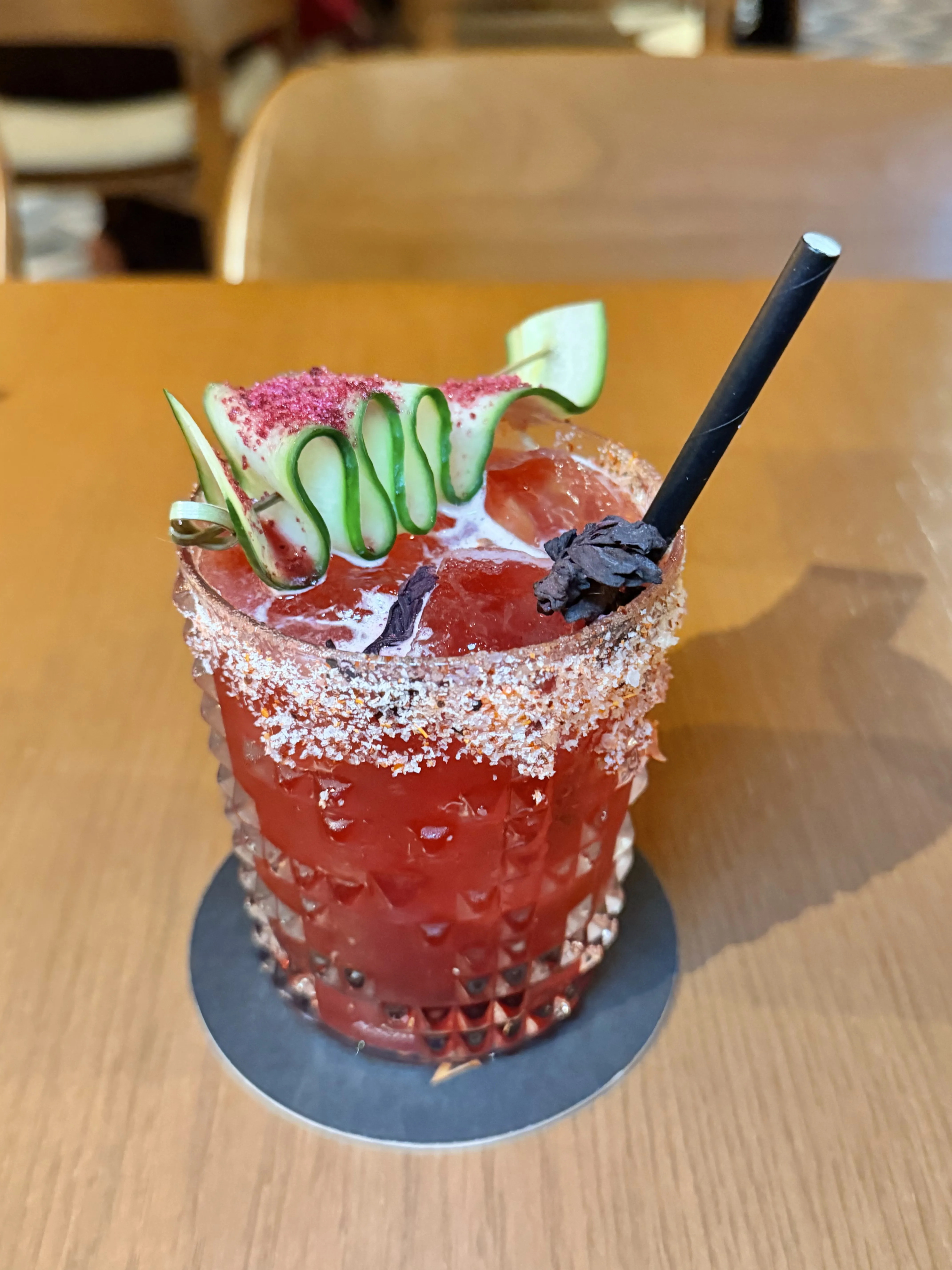 Mujeres Divinas cocktail with cucumber and watermelon garnish