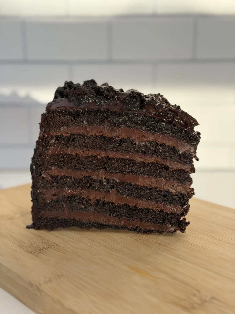 Thick slice of P.F. Chang's Great Wall chocolate cake with multiple dark chocolate layers on wooden board