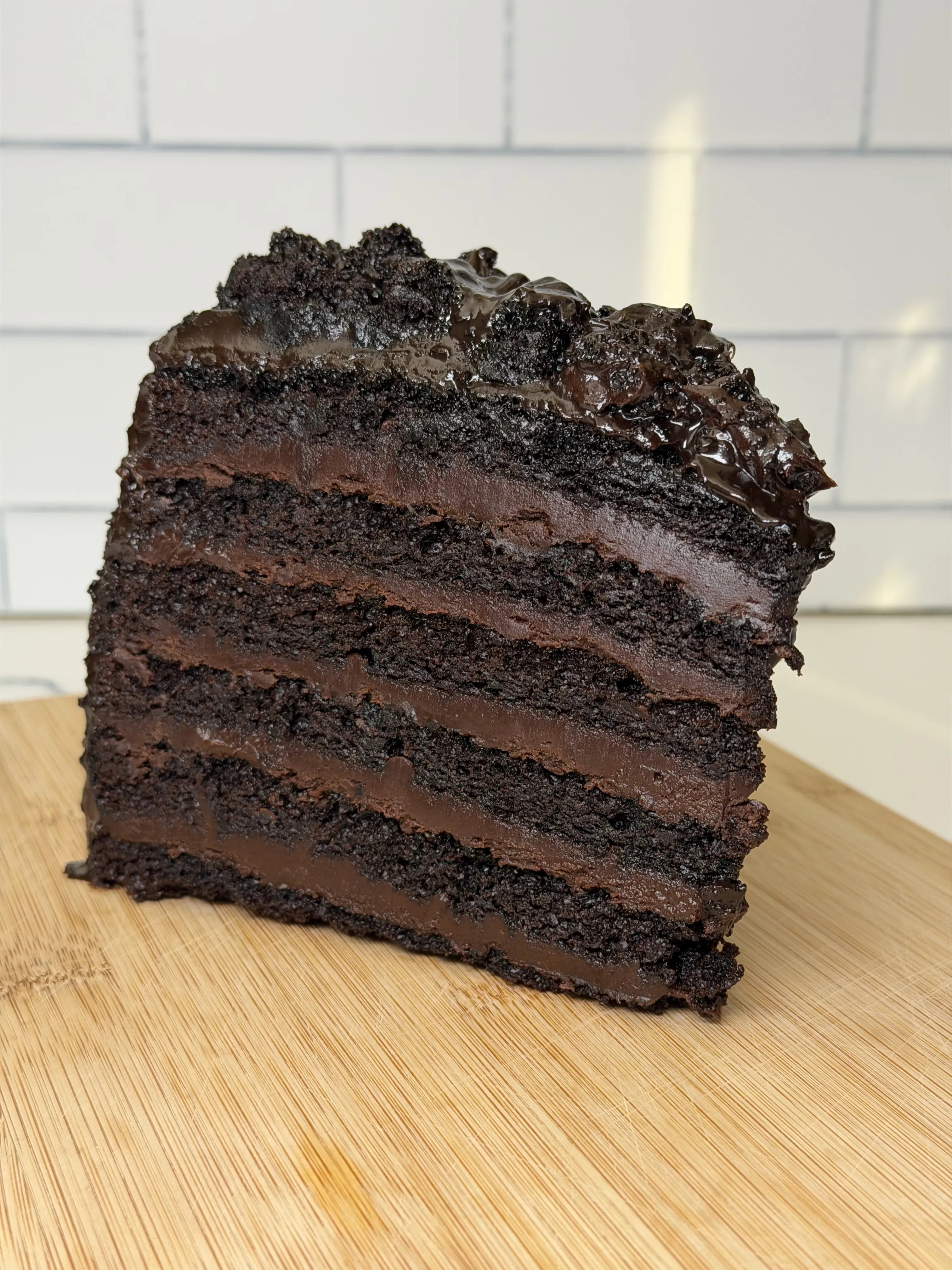 Layered slice of Great Wall of Chocolate cake showing six chocolate layers with ganache