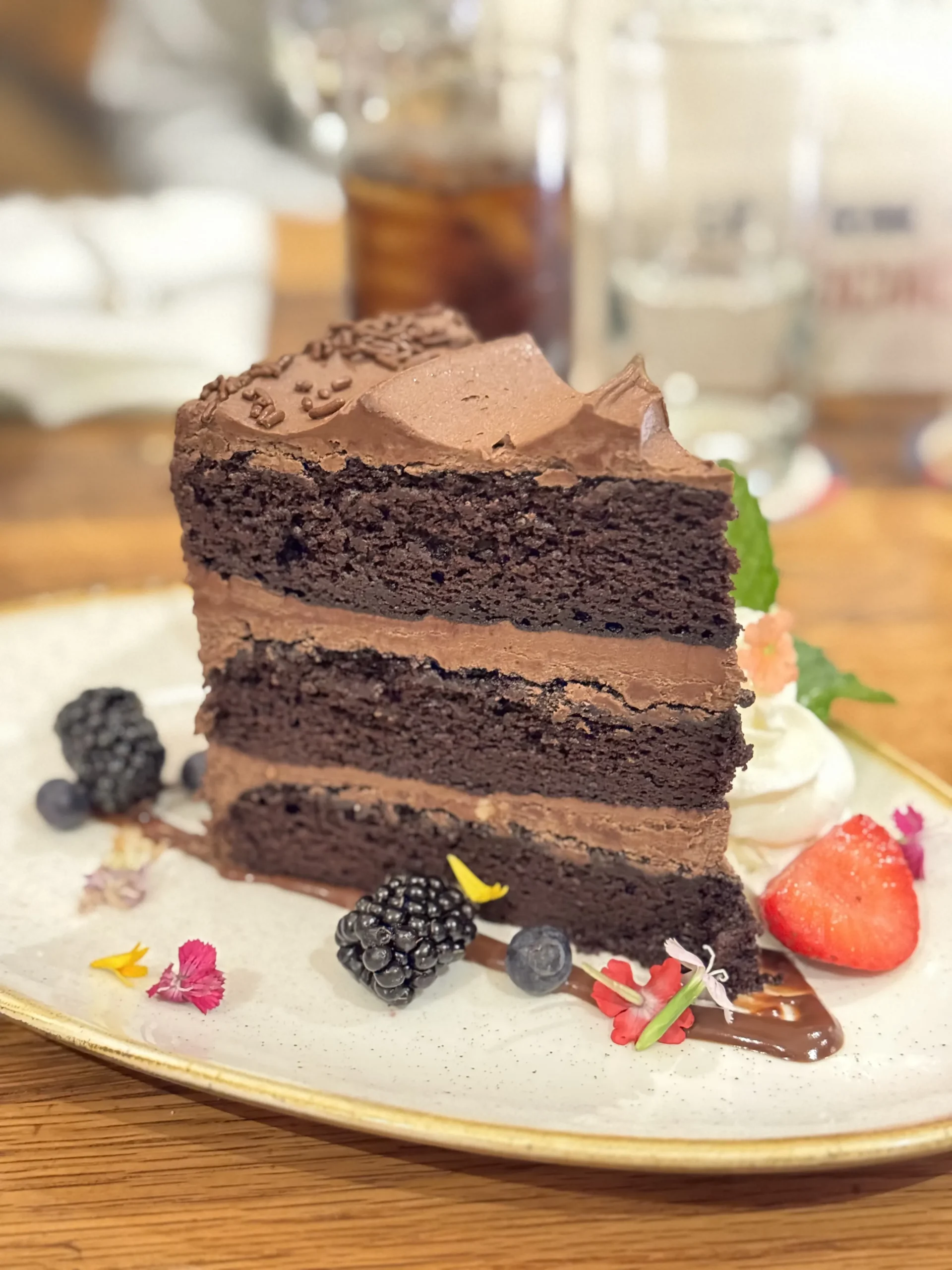 Triple-layer chocolate cake slice with berries
