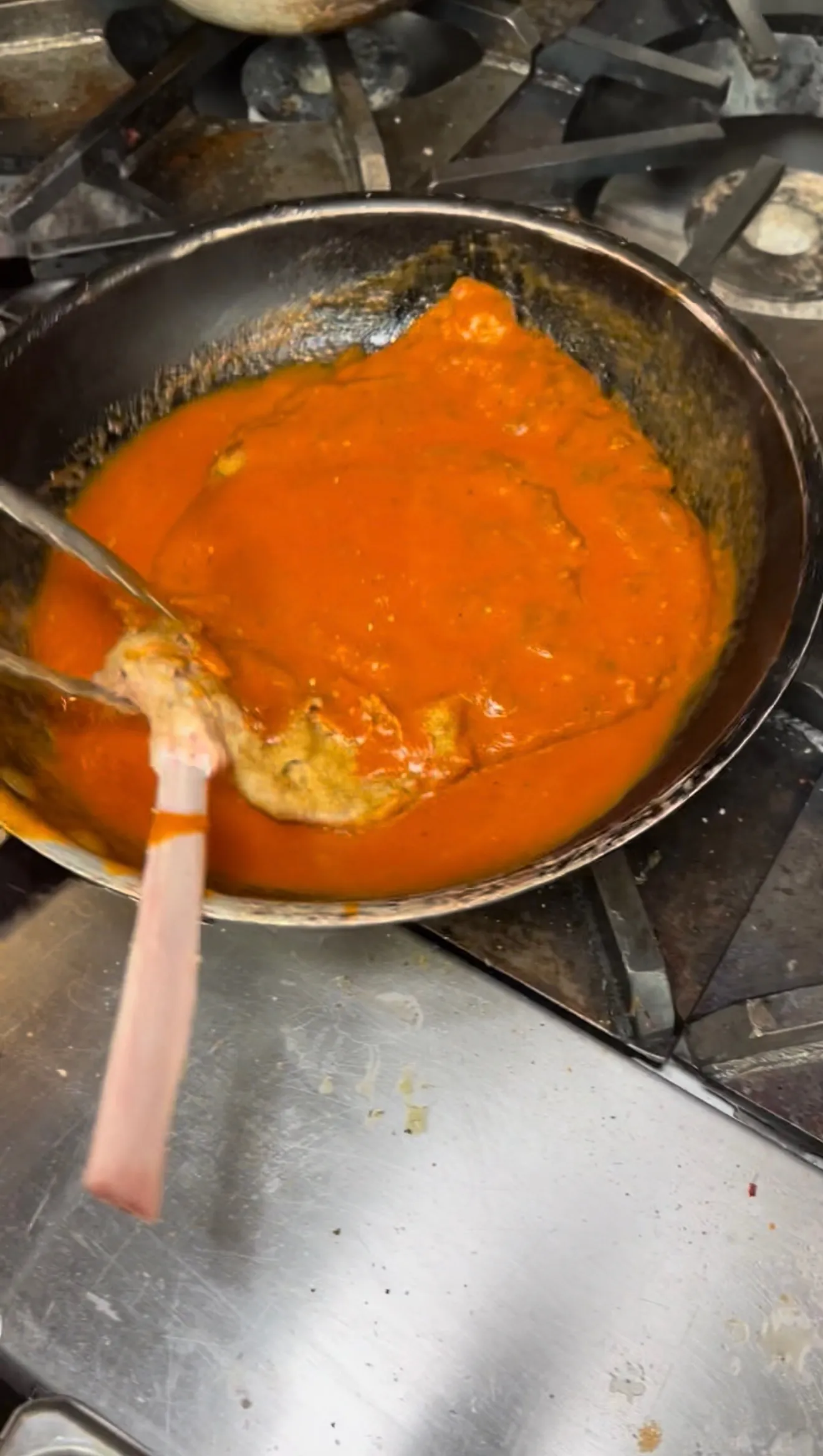 Veal chop sitting in tomato sauce in an oven-safe pan
