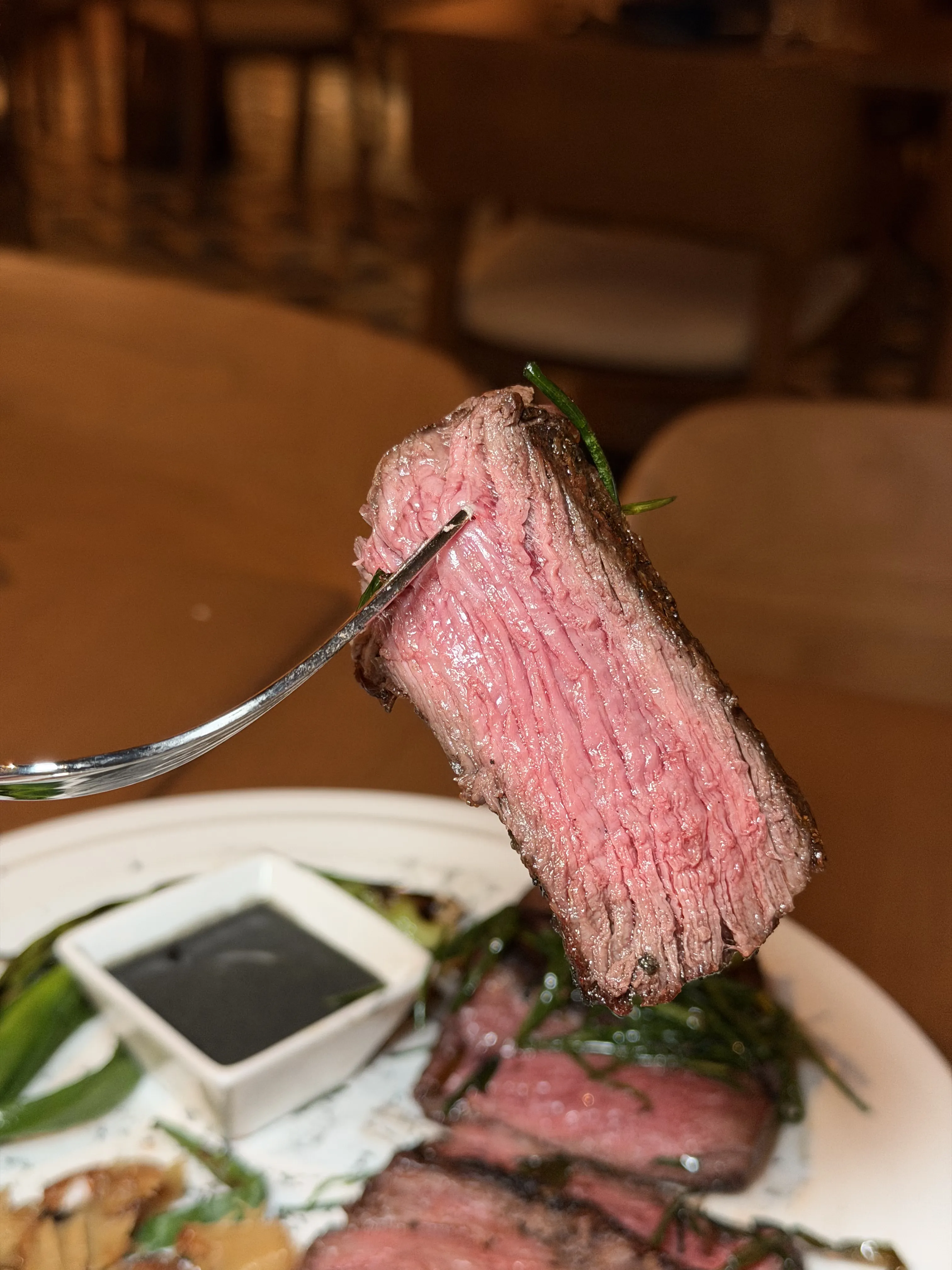 Medium-rare Wagyu spinalis steak slice on fork