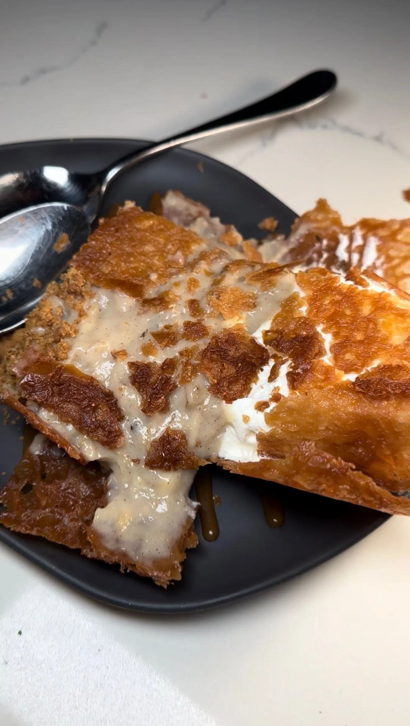 Bananas in a Box with crispy golden wonton wrappers and melted cheese on a dark plate