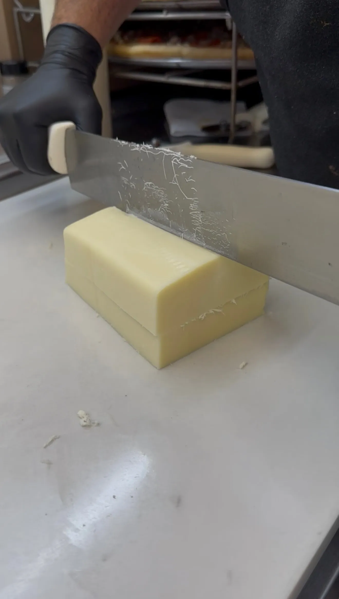Cutting a mozzarella block into thick sticks for fair-style mozzarella sticks
