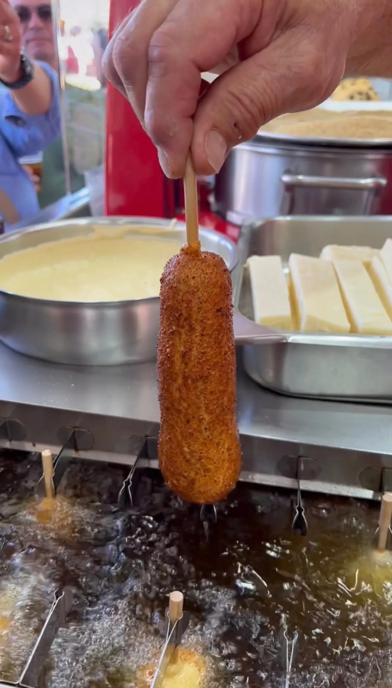 Fair-style mozzarella stick deep frying with a golden crust forming