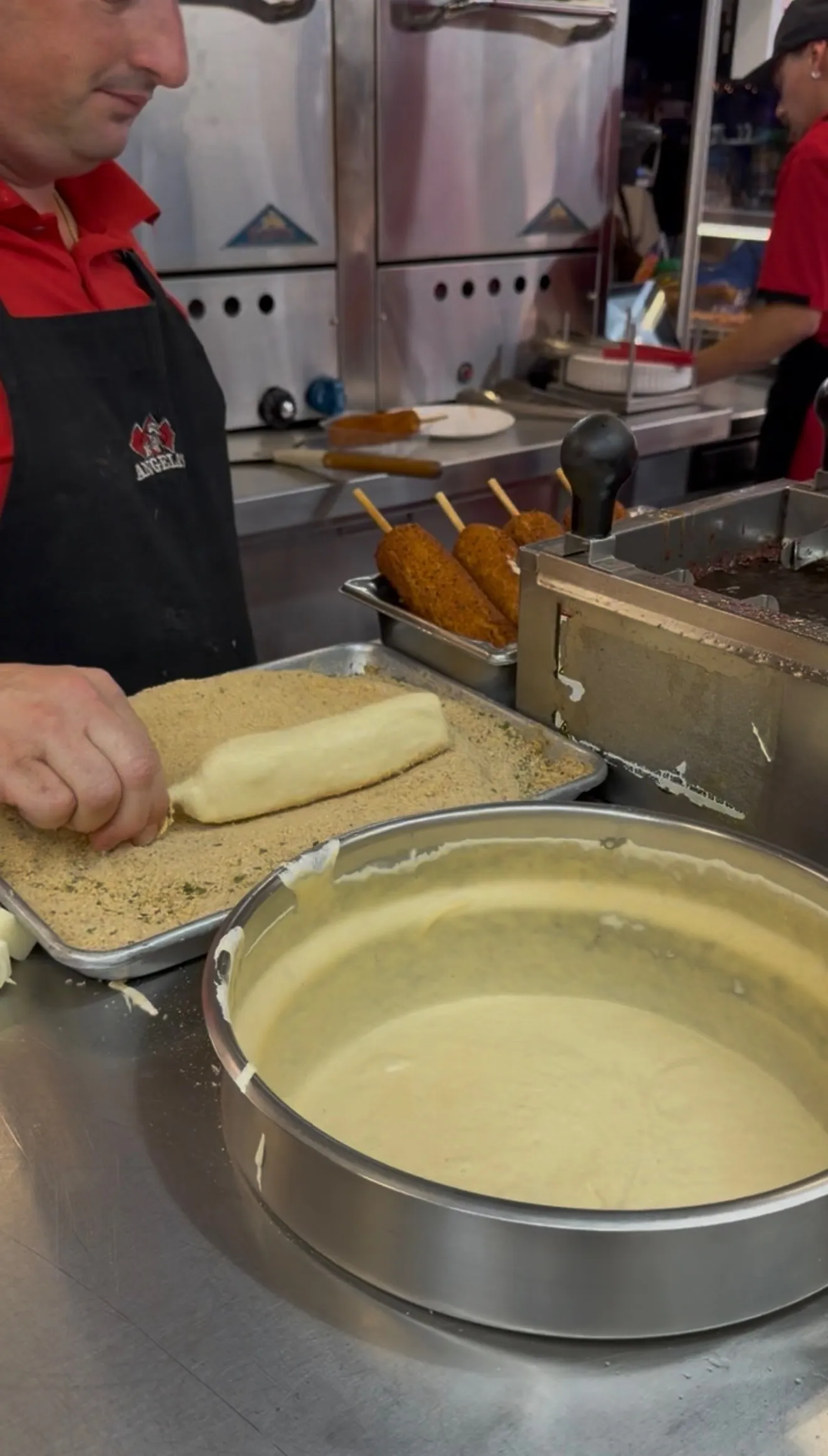 Fair-style mozzarella stick being prepared in a commercial kitchen