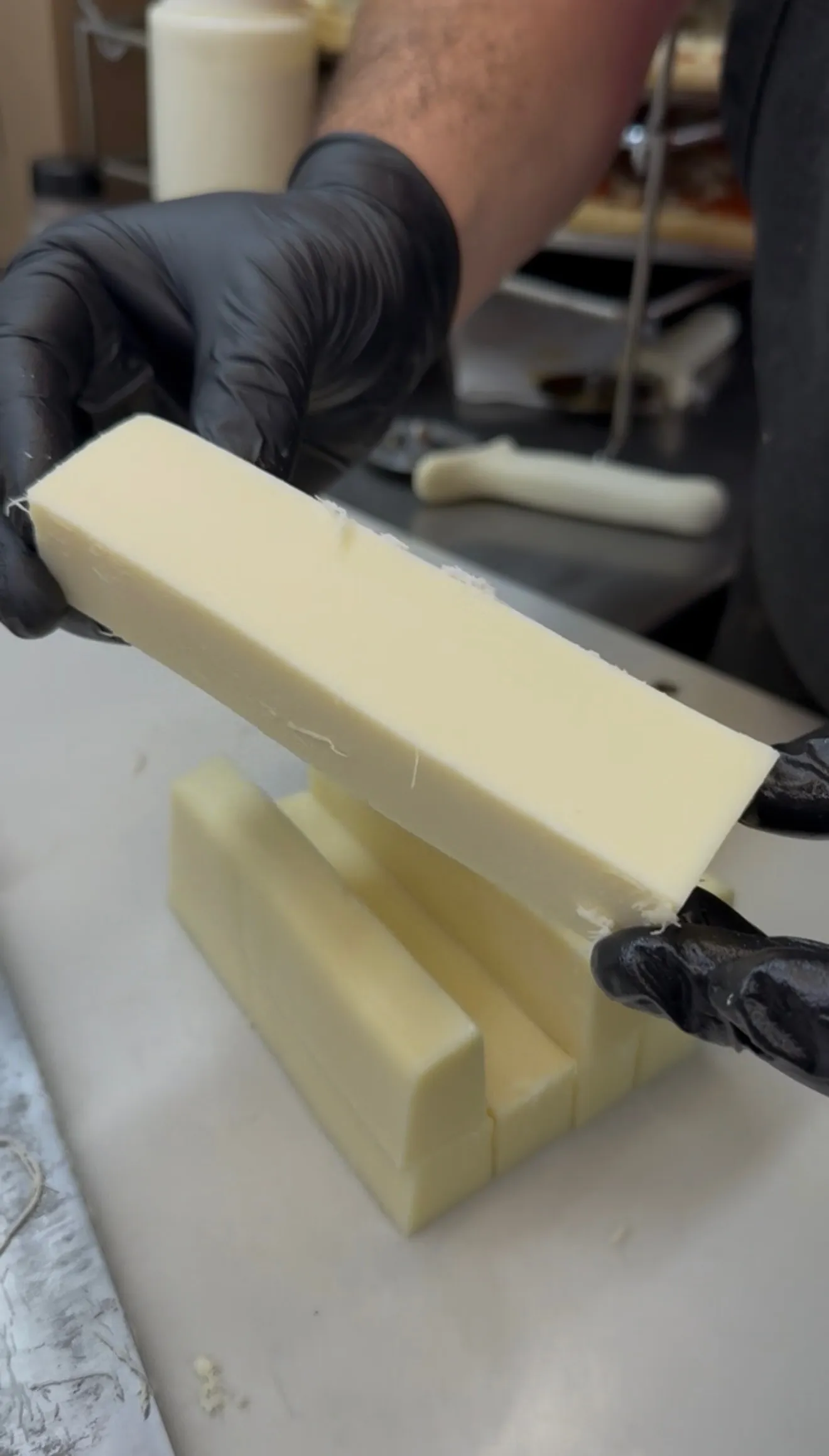 Mozzarella cheese sticks being prepared in a kitchen before battering